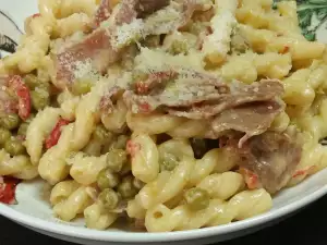 Gemelli met roomsaus, prosciutto en erwten
