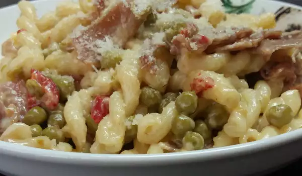 Gemelli met roomsaus, prosciutto en erwten