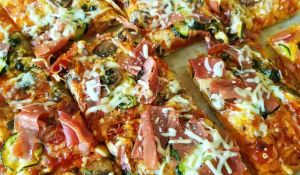Veganistische pizza met spinazie, champignons en courgette