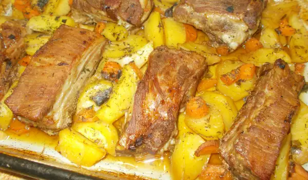 Varkensribbetjes met aardappeltjes en wortels uit de oven