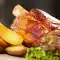 Varkens ijsbeen ham met aardappels uit de oven