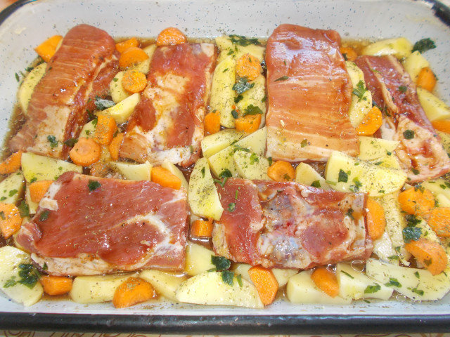 Varkensribbetjes met aardappeltjes en wortels uit de oven